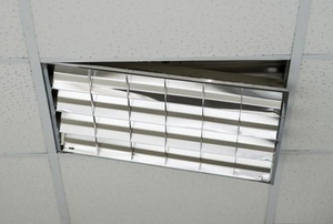 a ceiling with tiles and a broken track and falling light