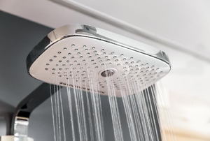 A rainfall showerhead with water flowing.