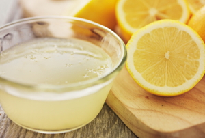 lemon juice in a bowl with fresh cut lemons on a cutting board