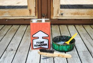 can of paint remover, a brush, and a container