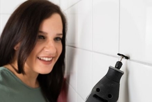 woman cleaning tile grout with a power tool
