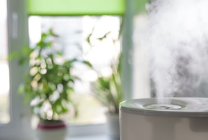 A humidifier with plants in the background.