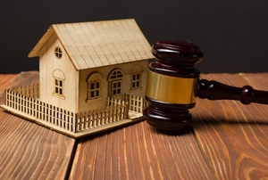 A small wood house and a gavel.