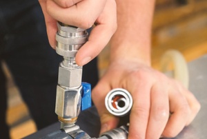 A person works on a ball valve.