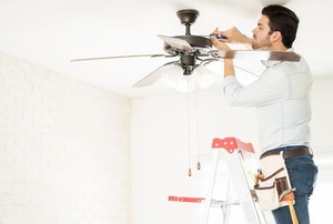 A man repairs a fan.