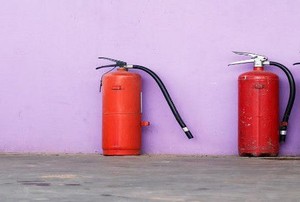 three fire extinguishers against a wall.