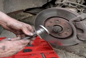 Someone using a brake caliper tool as they're changing brake pads.