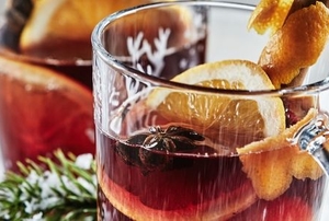 red wassail drinks with sliced citrus fruit and cinnamon