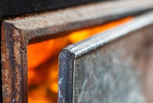 metal wood stove with door open to fire inside