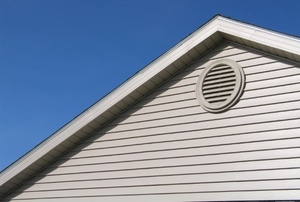 Attic vent against sky and roofline.