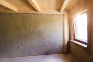 A right corner of a room with rafters in the ceiling, the right wall has a window in it.