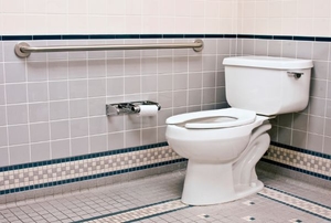 A bathroom with a grab bar next to the toilet. 