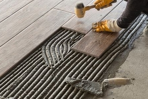 Worker placing floor tiles