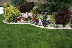 A lawn with stone edging and a flower bed.
