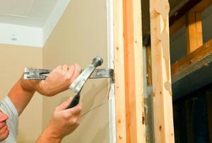 Using a pry bar and hammer to remove sheetrock
