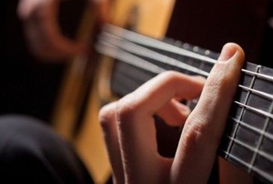 hands playing an acoustic guitar