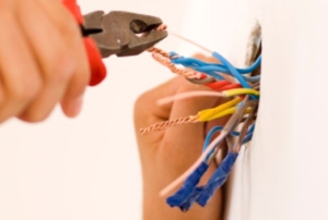 A jumble of wiring sticking out of a wall.
