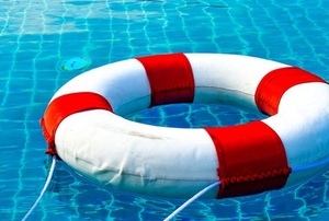 A lifeguard safety ring floating in a pool.