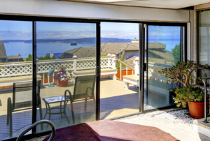 sliding screen doors between an interior and a deck above a coastal view