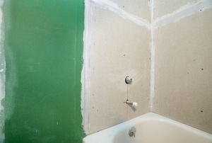 Drywall being installed in a bathroom.