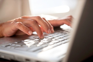A woman types on a keyboard.