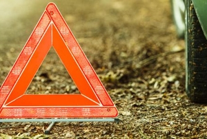An emergency triangle next to a car tire.
