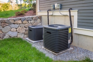 Twin air conditioning units outside of a home.