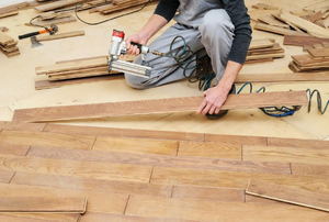 person installing wood flooring
