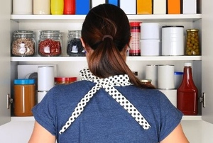 A woman looks at a pantry.