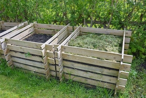 A series of compost bins in a grassy yard.