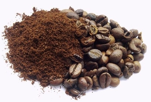 A half and half pile of coffee grounds and coffee beans.