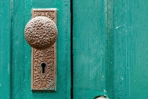 antique doorknob on a green door
