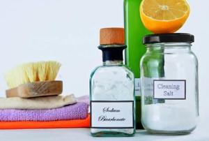 A range of non-toxic cleaning products in glass jars and bottles.