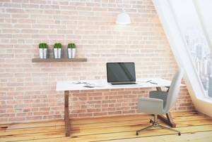 Office space next to a window and brick wall