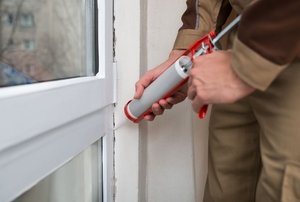 Silicone caulk being used to seal around a window.