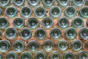 A wall made of glass bottles, filled between with cement.