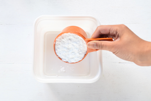 A measuring cup full of baking soda.