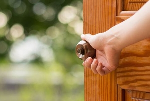 A woman opens a door.