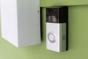 doorbell with camera on green wall