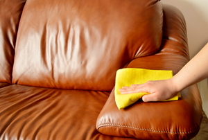 person wiping a leather couch