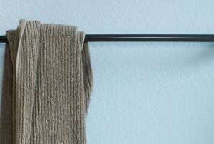 towel hanging on rod on bathroom wall