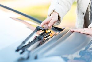 a hand touching a Windshield Wiper