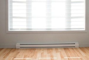 A singular baseboard heater installed below the window in a bedroom.