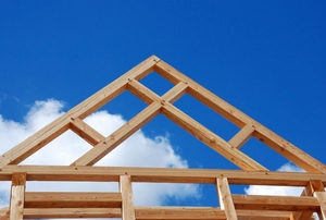 A wooden roof truss secured to a wooden housing frame.