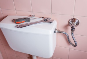 toilet with tools on top