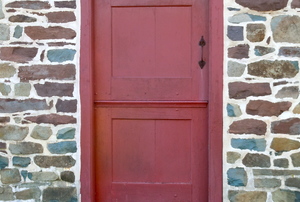 Red Dutch door against a brick exterior