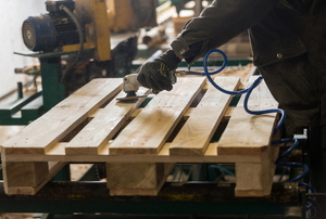 A wood pallet being sanded.