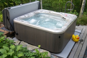 hot tub on a deck with a rubber ducky next to it