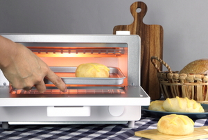 hand baking small bread loaves in toaster oven
