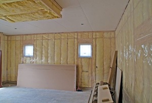 A room with insulation and an installed vapor barrier.